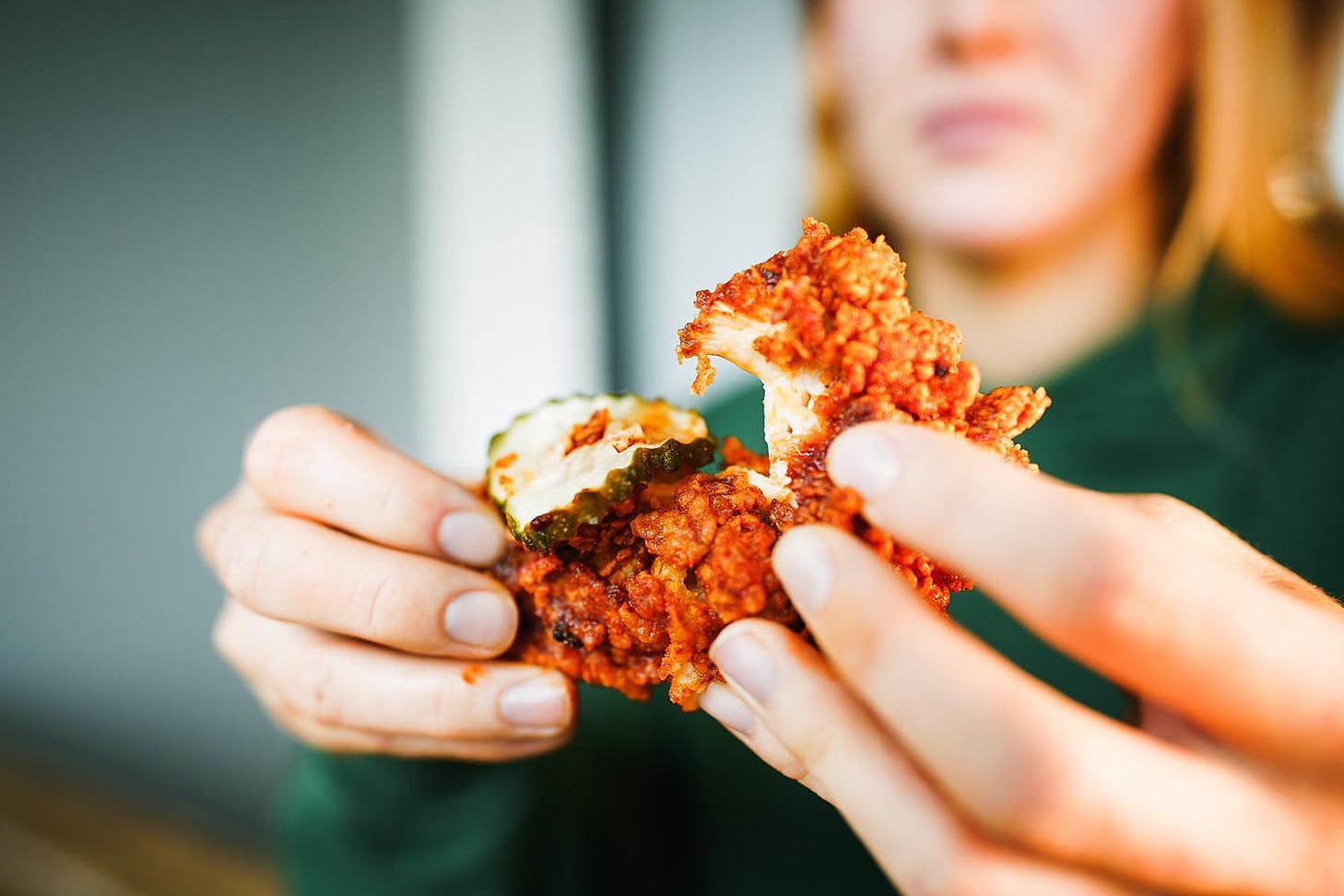 Someone pulls apart some crunchy, juicy chicken from Brew'd Hawt.